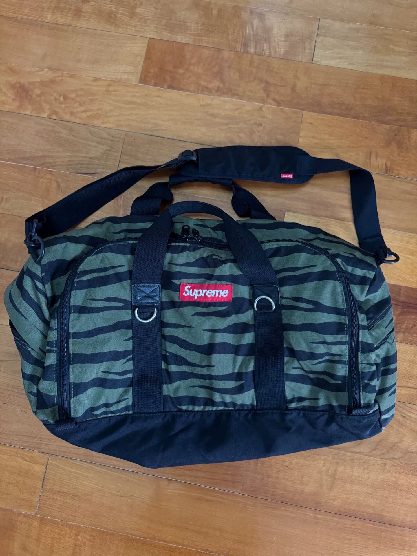 supreme camouflage duffle bag with red tag