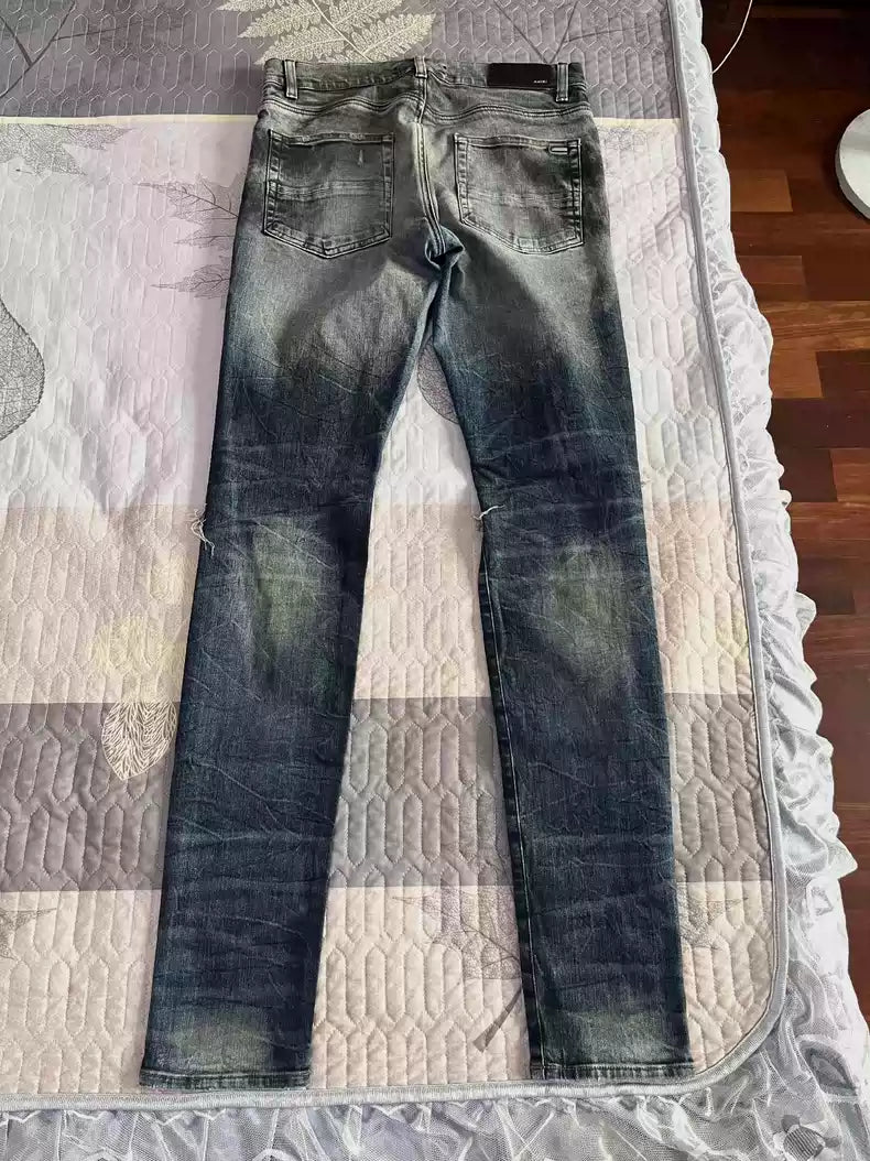 Amiri's old oil stain distressed damaged knees jeans