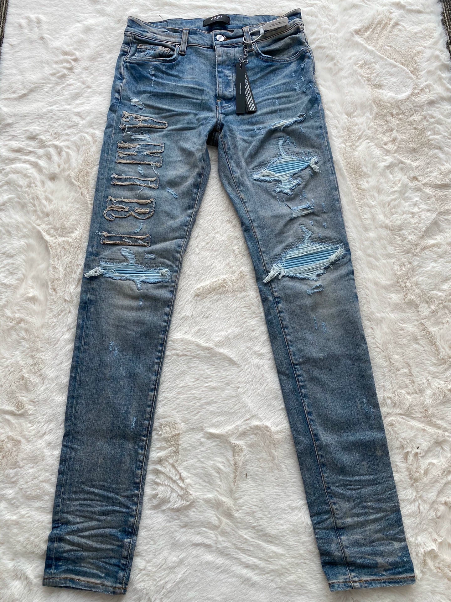 Amiri washed blue and blue patchwork logo jeans