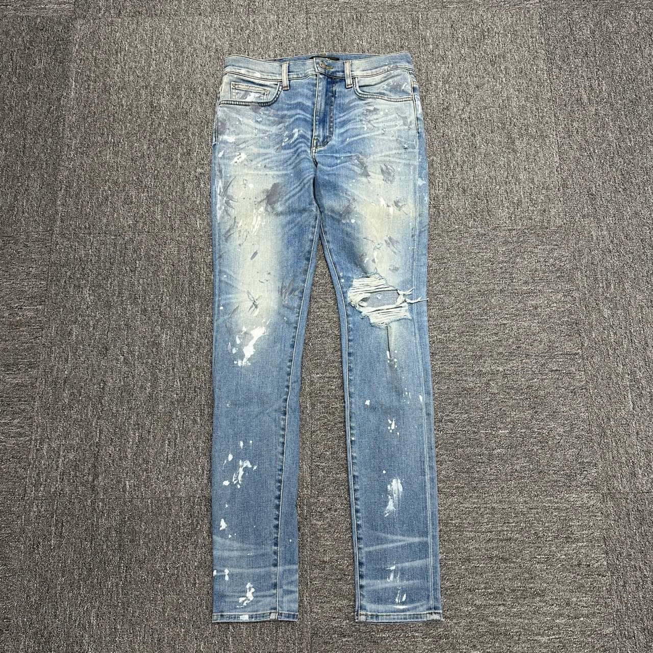 Amiri single knee tear splashed ink jeans