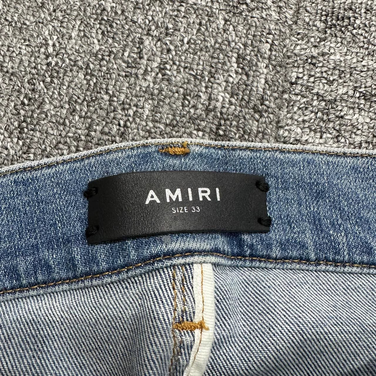 Amiri single knee tear splashed ink jeans