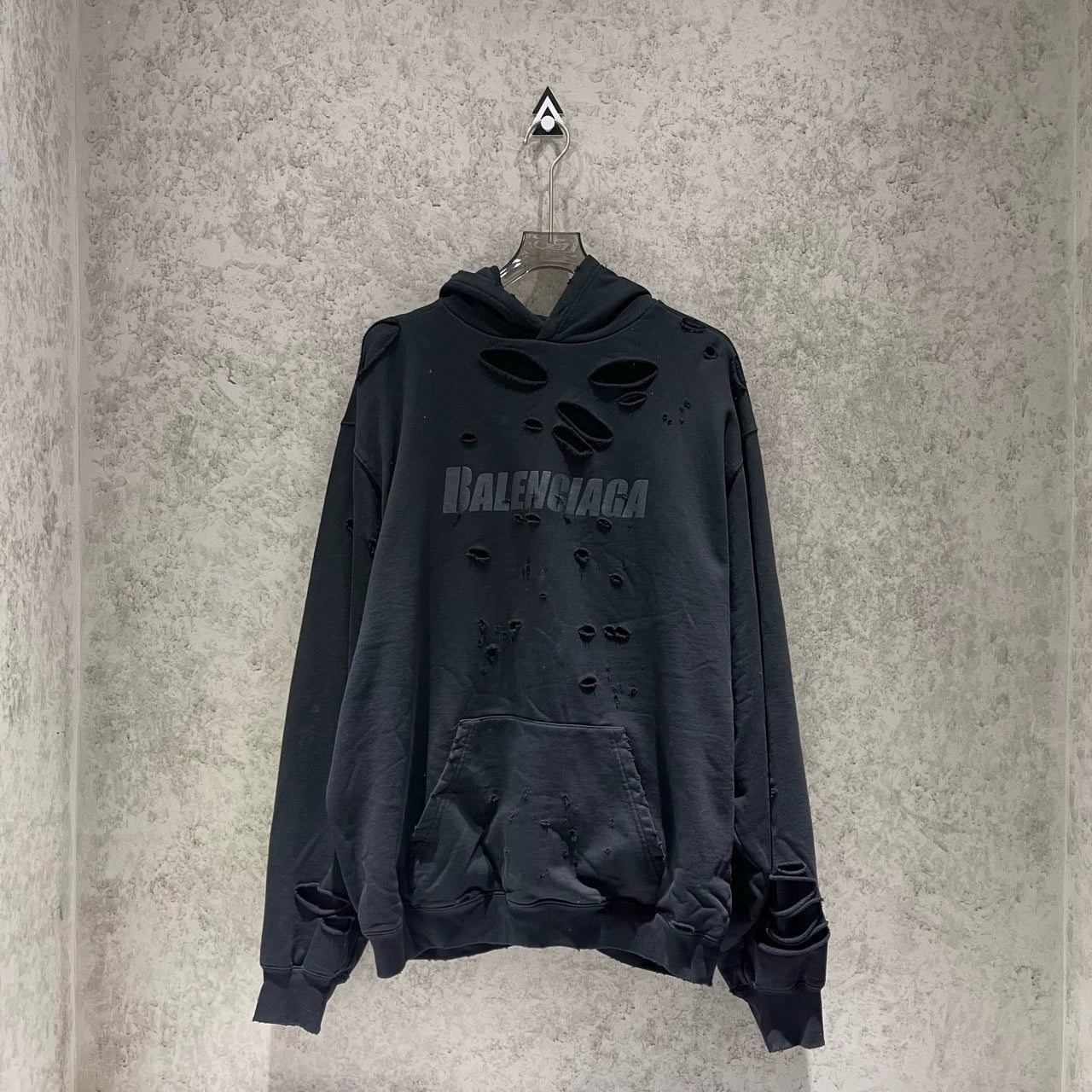 Balenciaga black logo is worn out with holes making a hooded sweatshirt