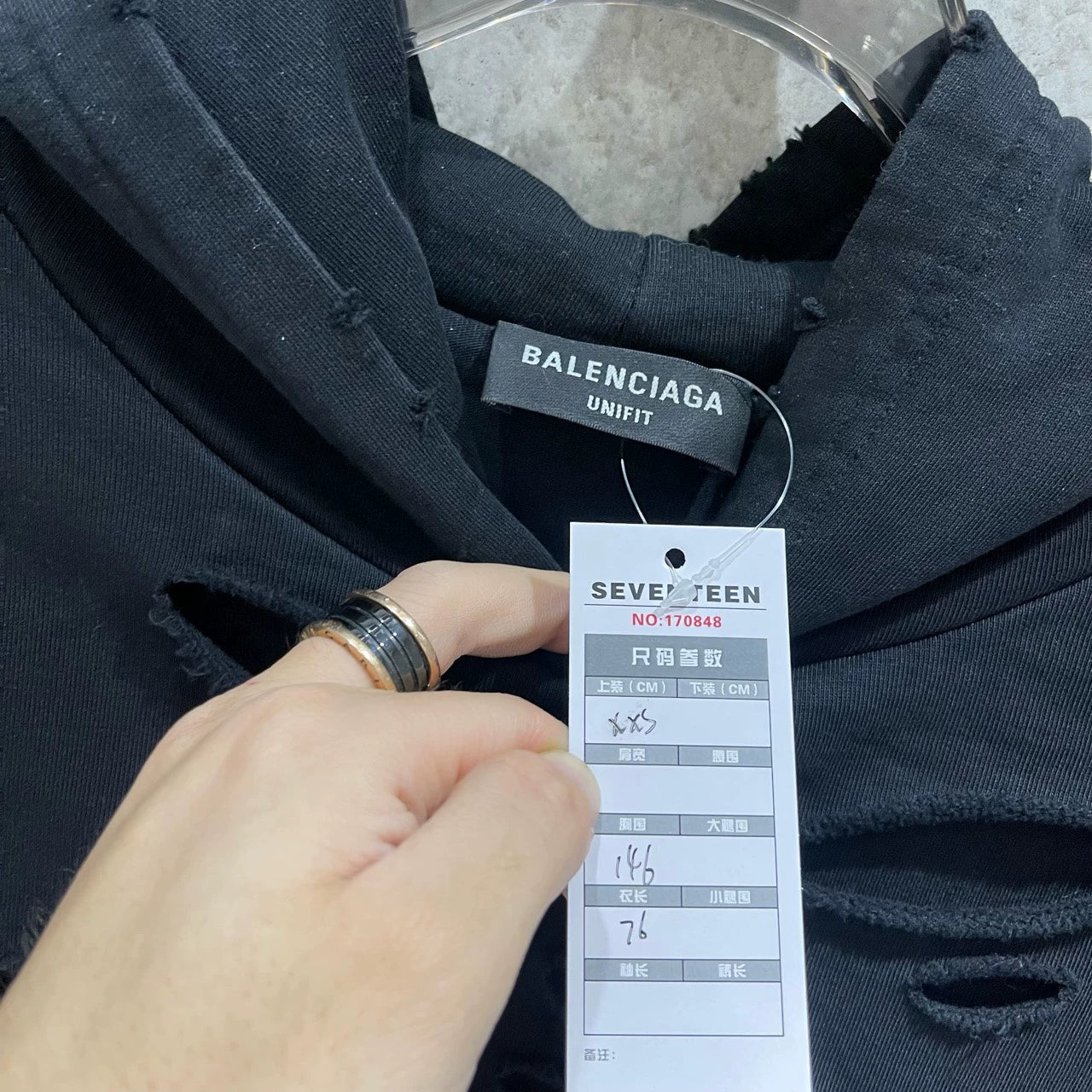 Balenciaga black logo is worn out with holes making a hooded sweatshirt