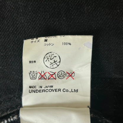 embroidered black denim pants by Undercover