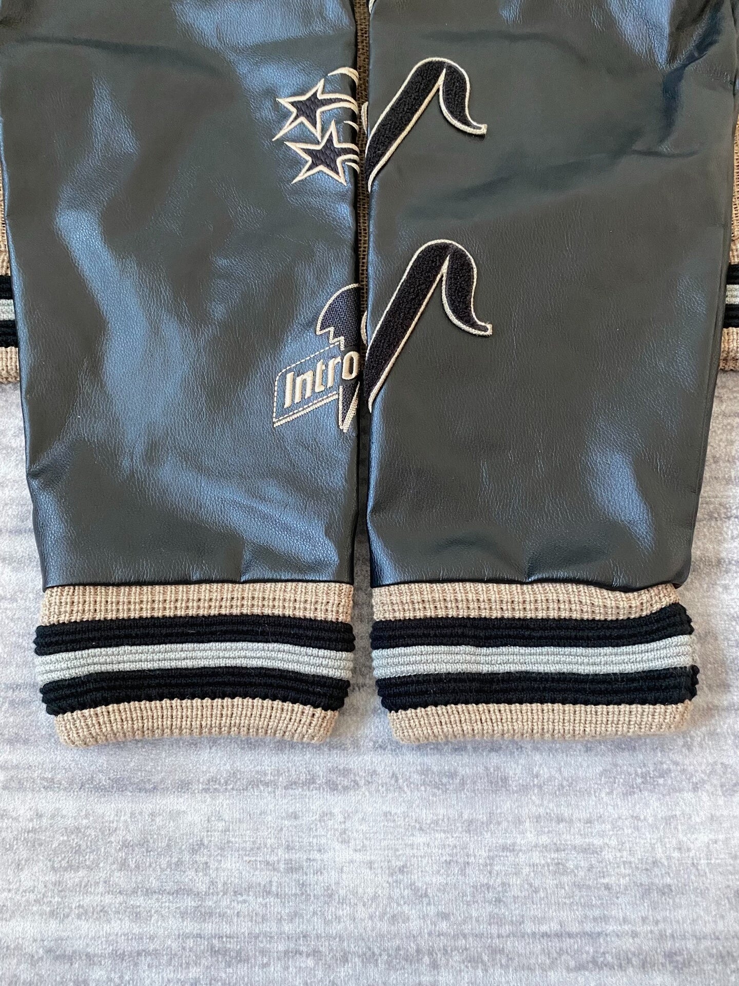 beige baseball jacket with leather sleeves