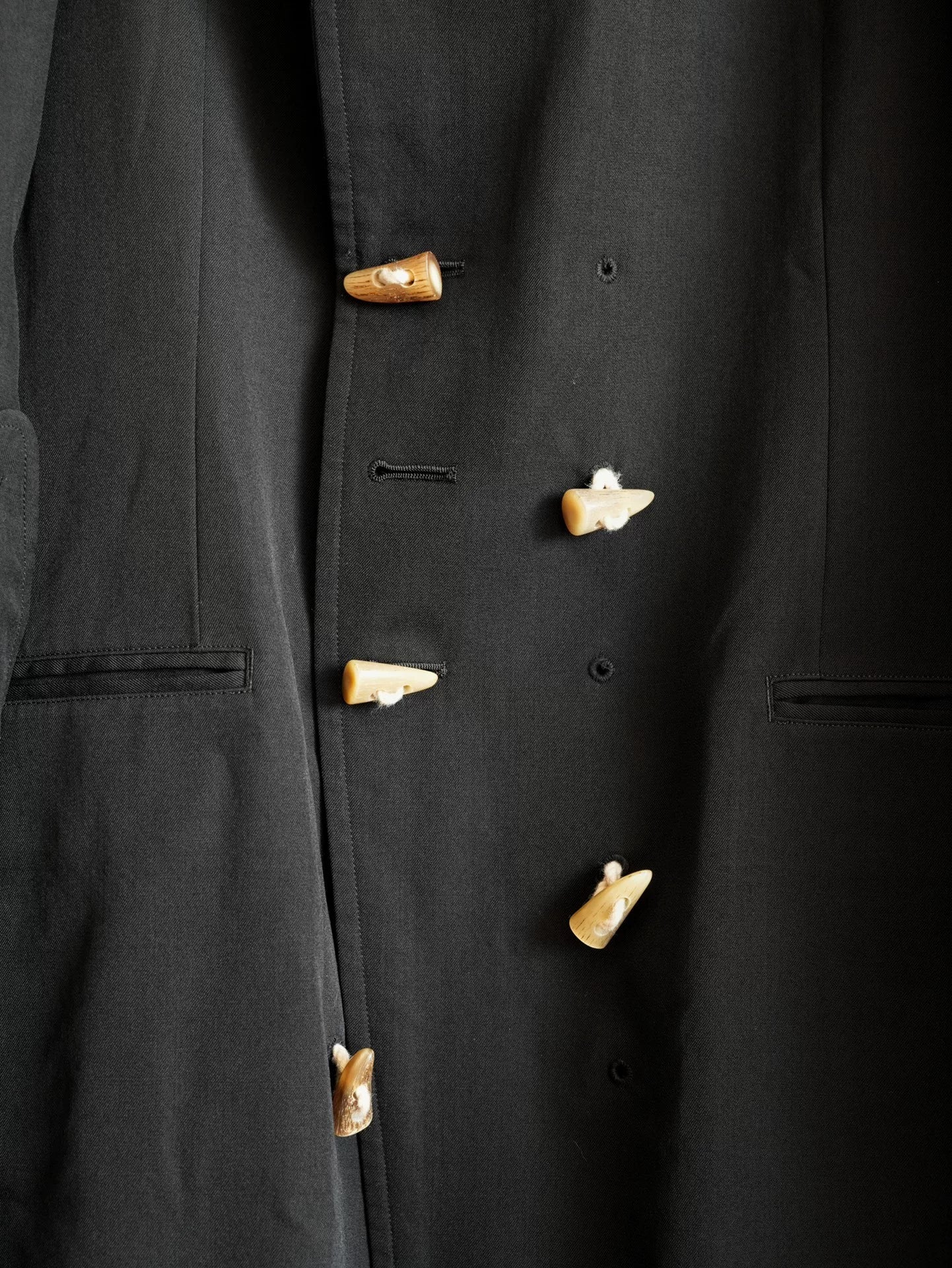 black double-breasted horn-button coat