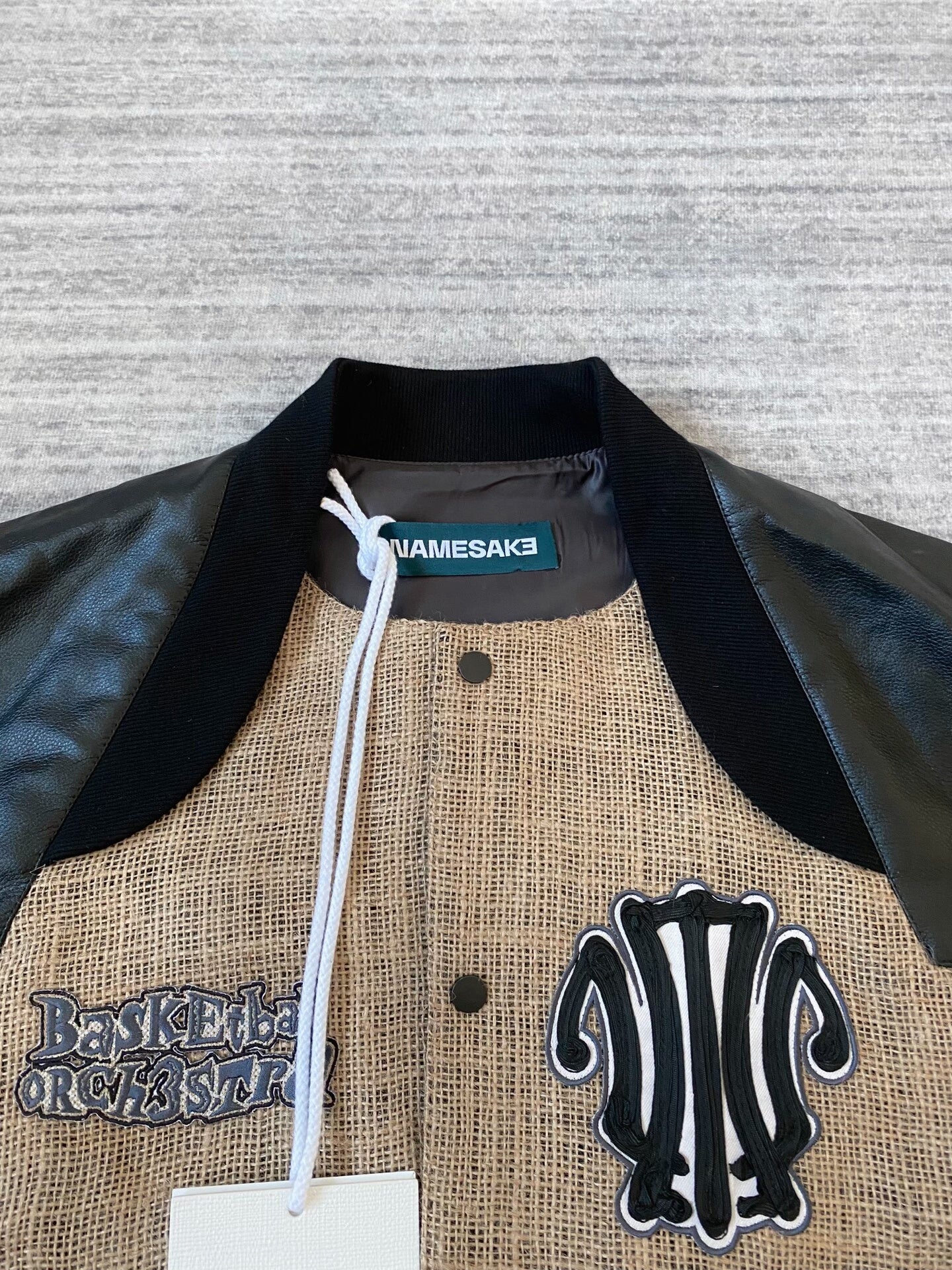 beige baseball jacket with leather sleeves