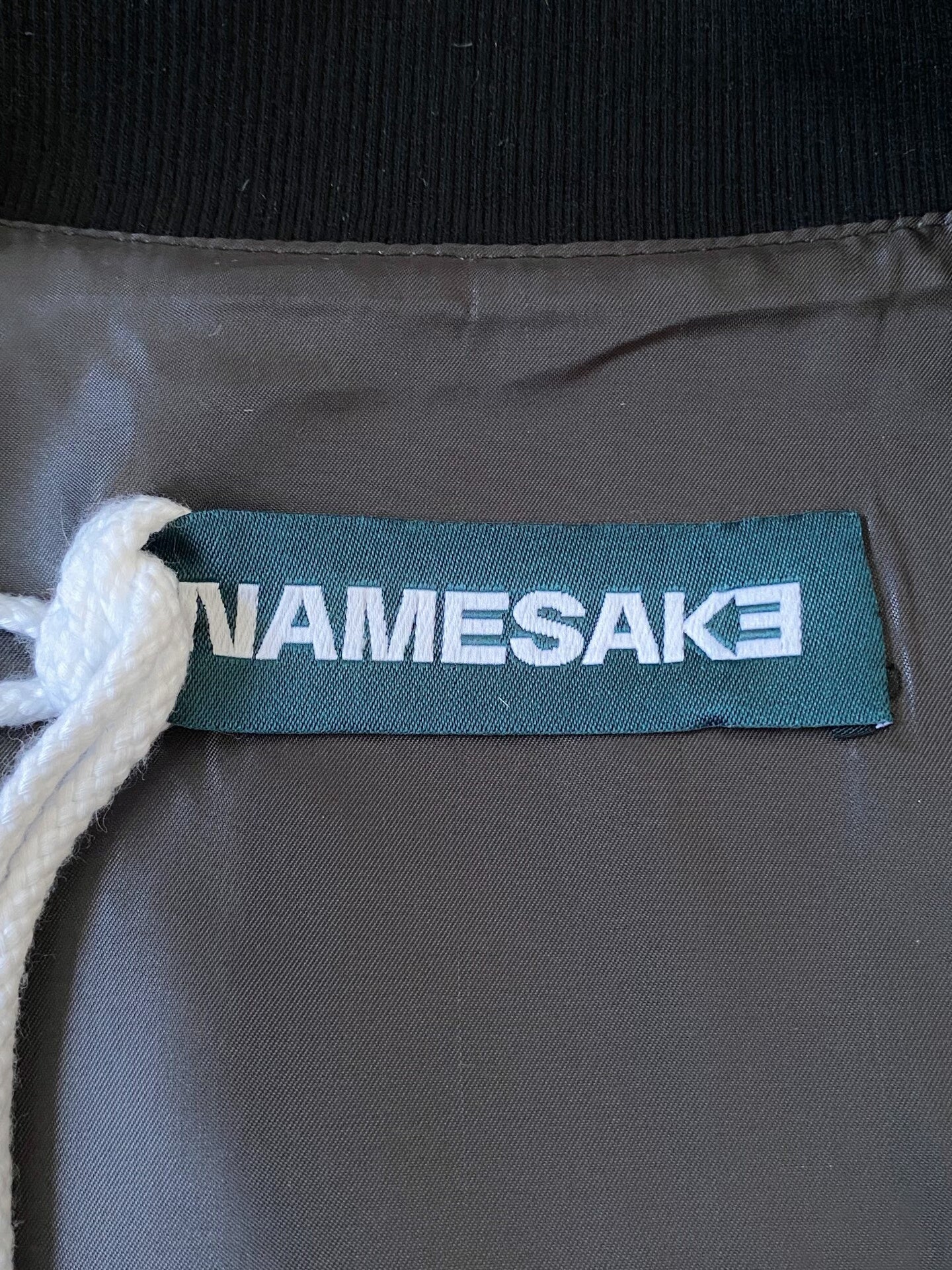 beige baseball jacket with leather sleeves