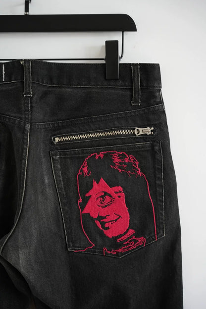 embroidered black denim pants by Undercover