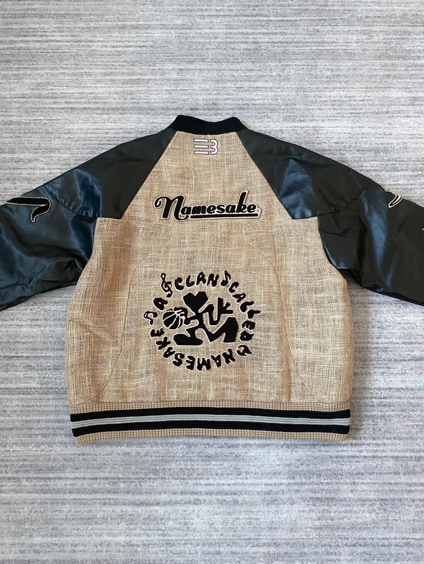 beige baseball jacket with leather sleeves