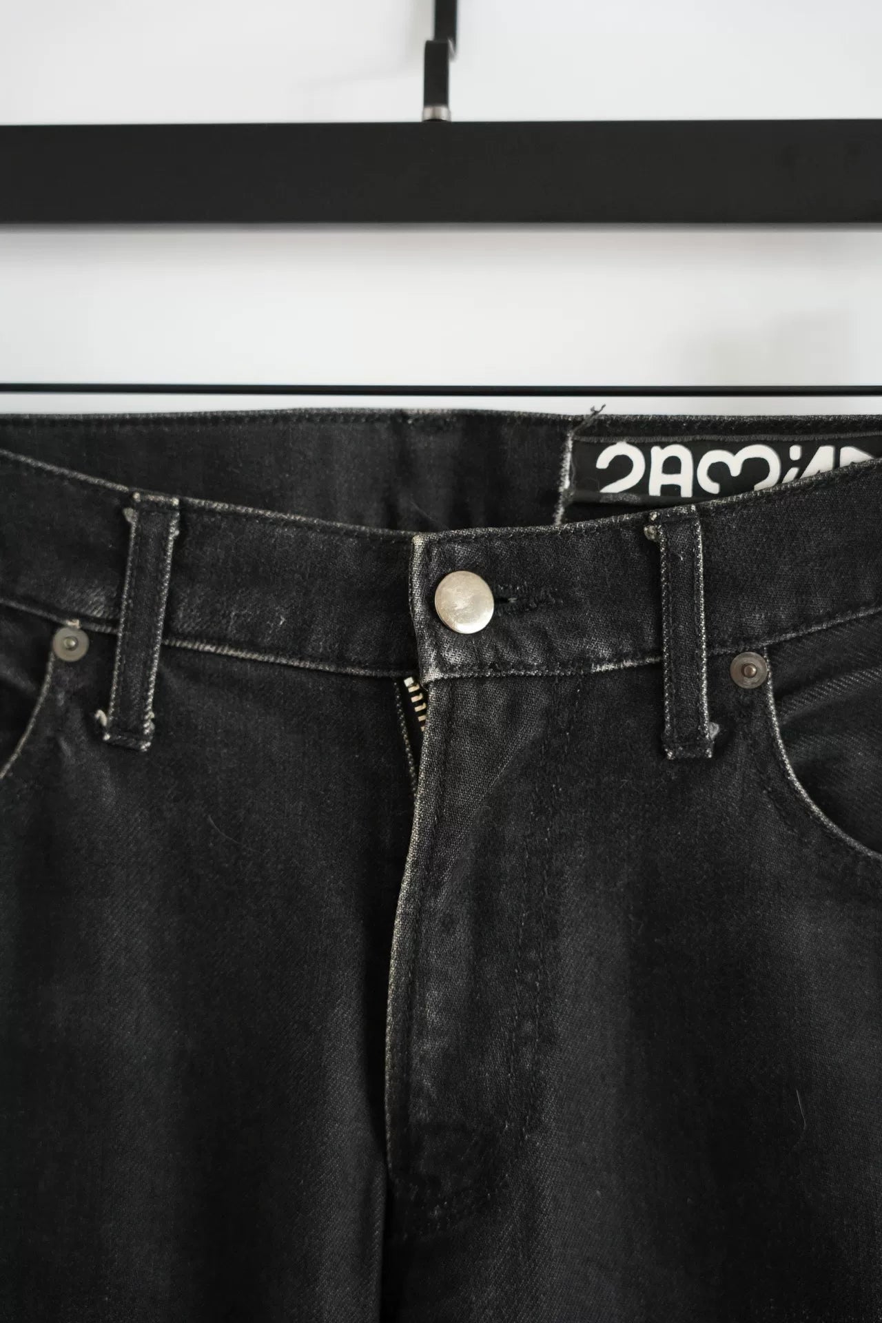 embroidered black denim pants by Undercover